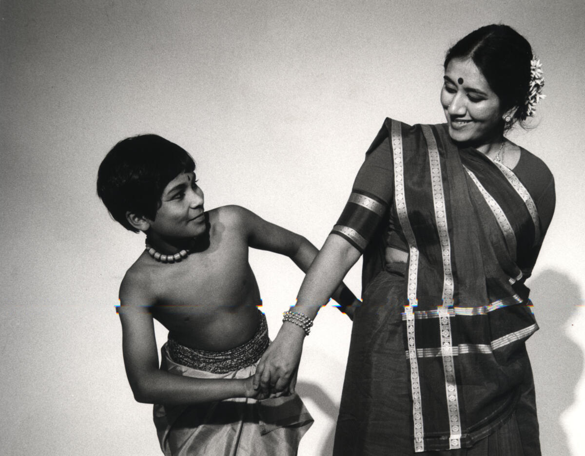 Woman and young boy with intertwined arms