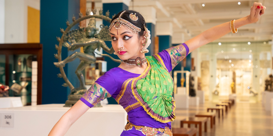 ornately dressed South Asian dancer depicted dancing in a museum