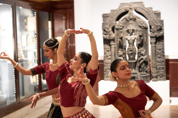 group of South Asian dancers in a museum setting