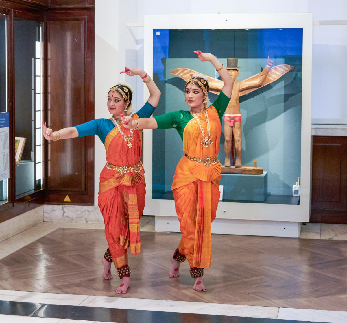 two South Asian dancers in a museum setting