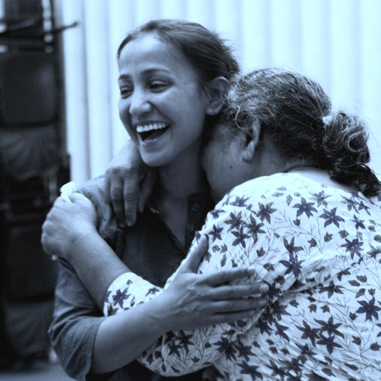 Two women laugh and hug