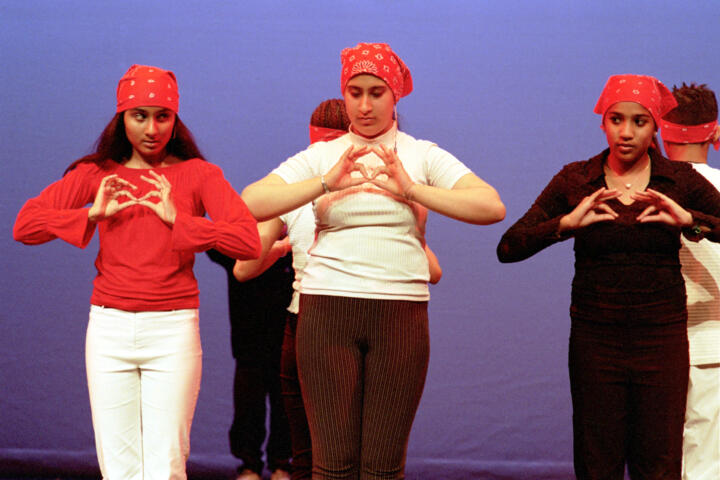 Group of young people performing in bright costumes
