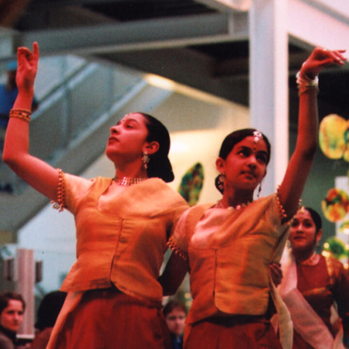 South Asian dancers perform to a crowd