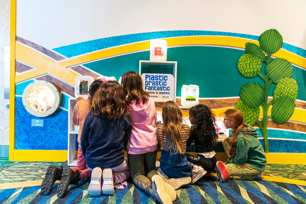 children explore an exhibition of colourful plastics