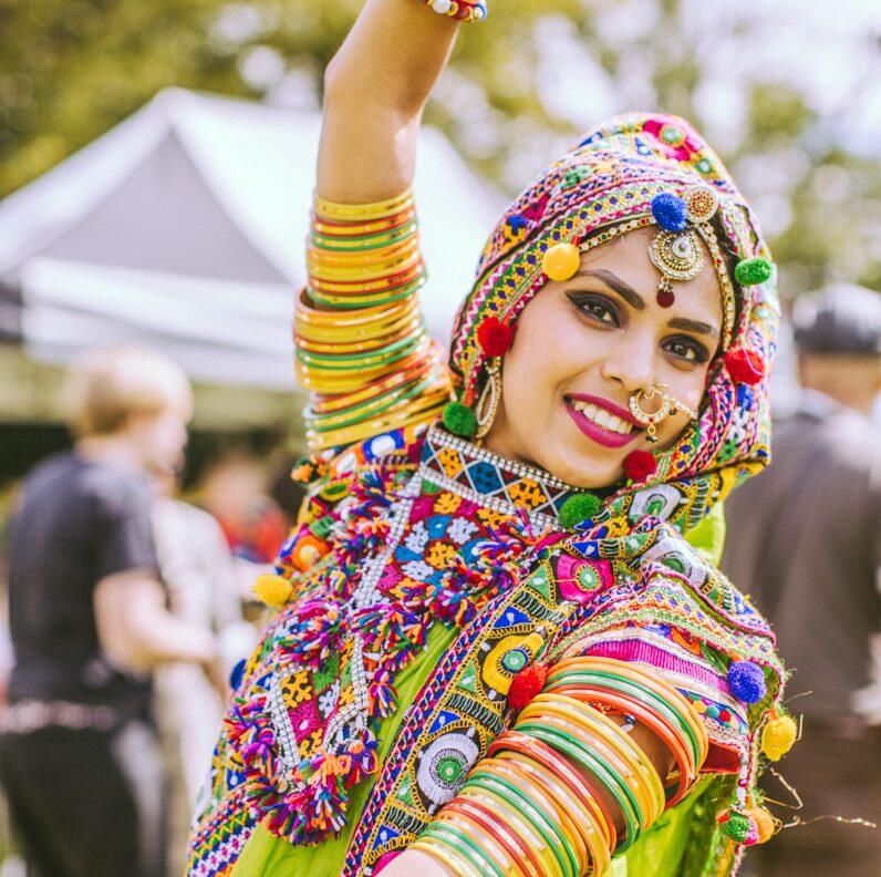 South Asian dancer in ornate dress performing at a street festival