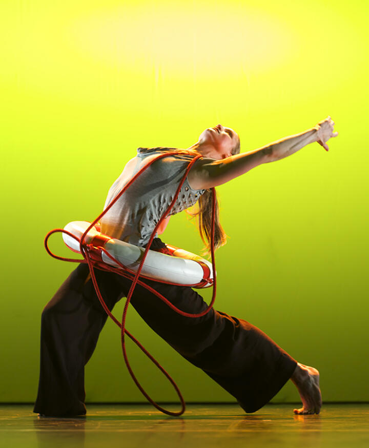 dancer with a life buoy on a brightly lit stage