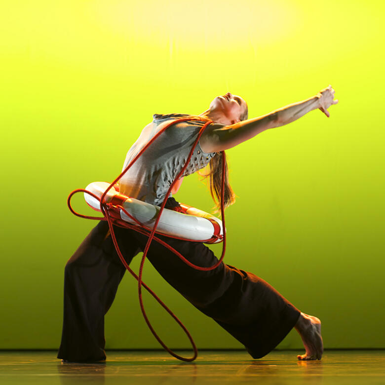 dancer with a life buoy on a brightly lit stage