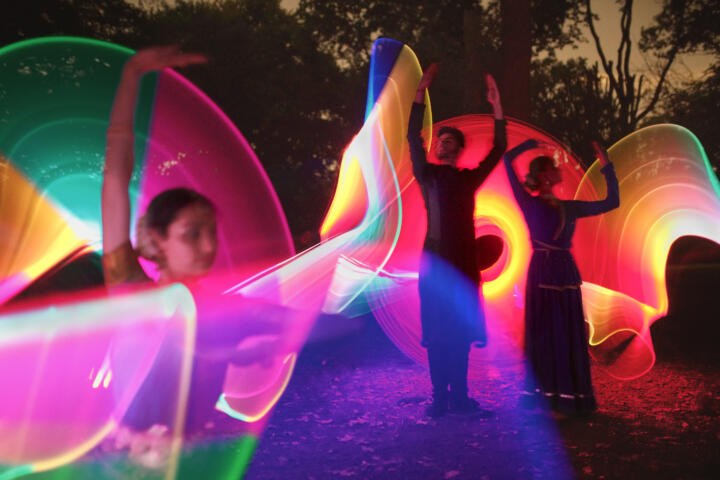 South Asian dance in a forest setting captured in slow motion by colourful traces of light