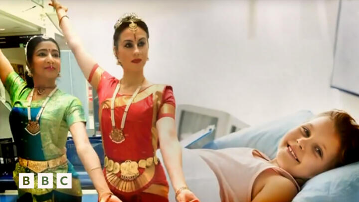 South-Asian dancers and child in a hospital bed