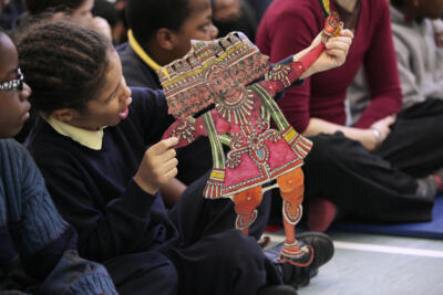school children holding a puppet during an arts and dance workshop