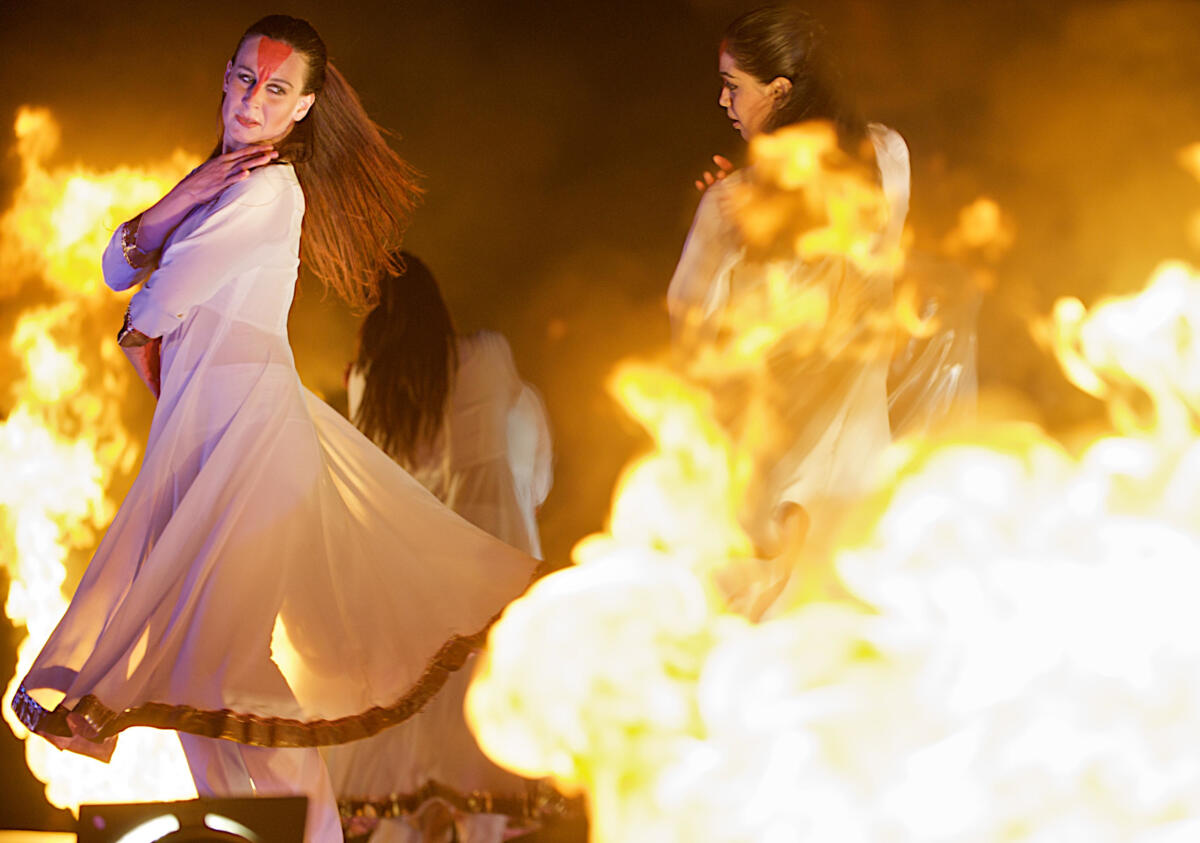 dance performers emerging from flames