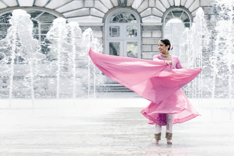 dancer in bright sari dancing in a fountain