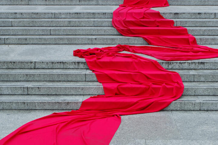 draped red silk material flows down concrete steps