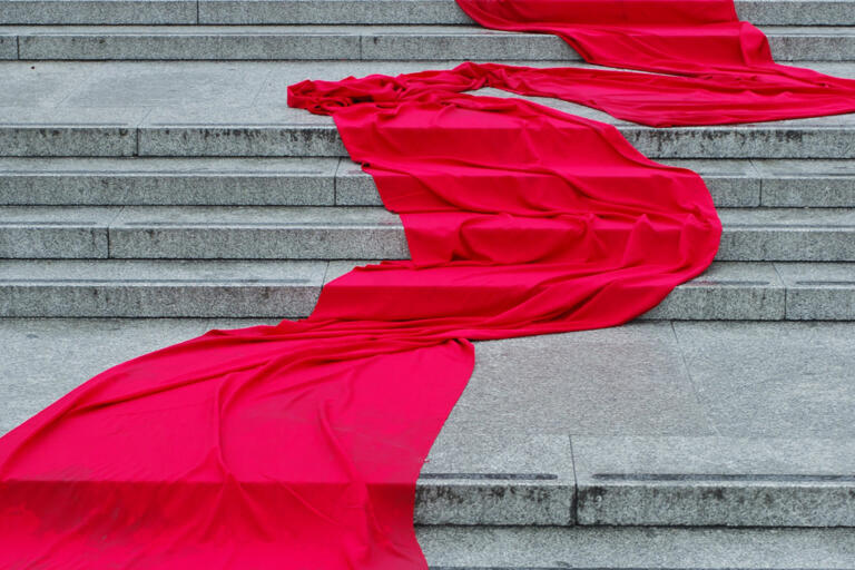 draped red silk material flows down concrete steps