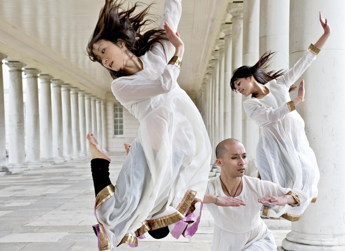 group of dancers perform against classic columned architecture